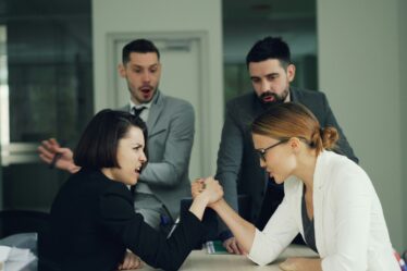 kobiety w biurze siłujące się na rękę