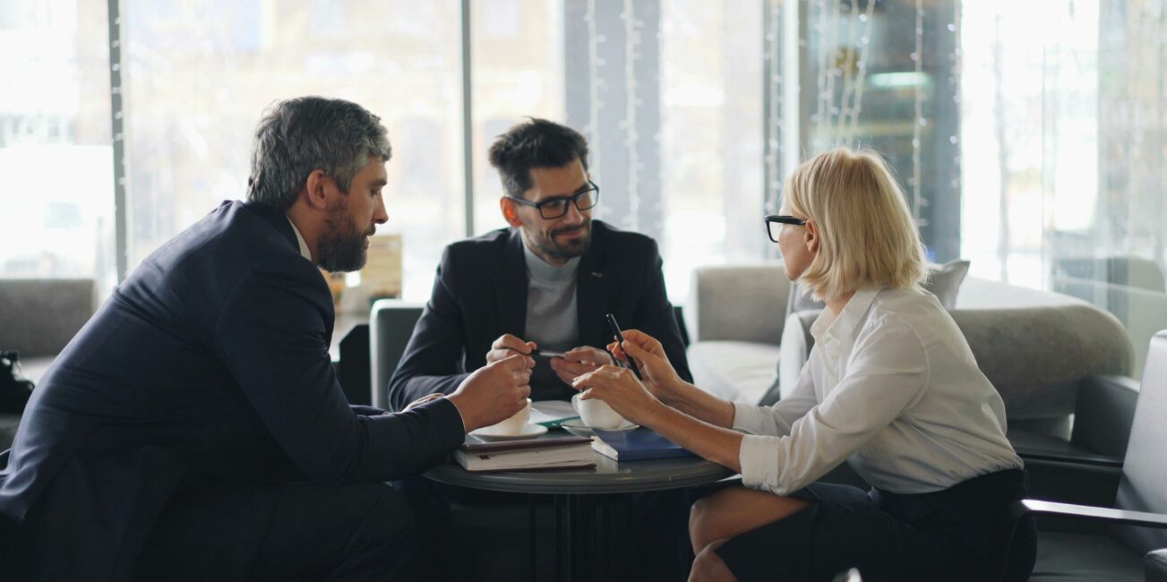 grupa ludzi siedzących naprzeciwko siebie