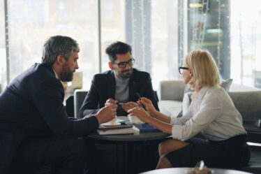 grupa ludzi siedzących naprzeciwko siebie