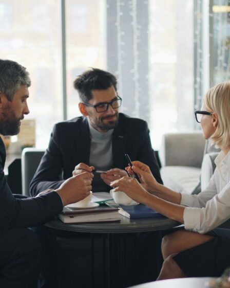 grupa ludzi siedzących naprzeciwko siebie
