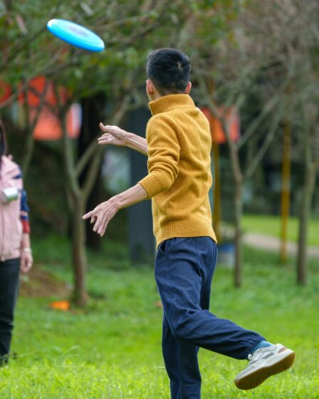 mężczyzna w parku rzucający frisbee do kobiety